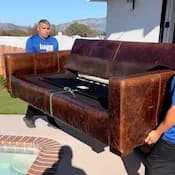 2 Lugg movers carrying a leather sofa