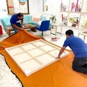 2 Lugg movers wrapping a piece of art for delivery