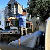 Lugg mover strapping down furniture in pickup truck