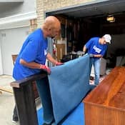 Lugg movers wrapping furniture in storage unit