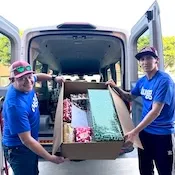 2 Lugg movers delivering Christmas gifts to a donation center