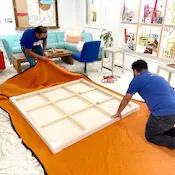 2 Lugg movers wrapping a piece of art for delivery