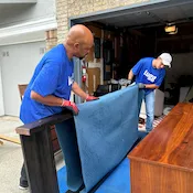 Lugg movers wrapping furniture in storage unit