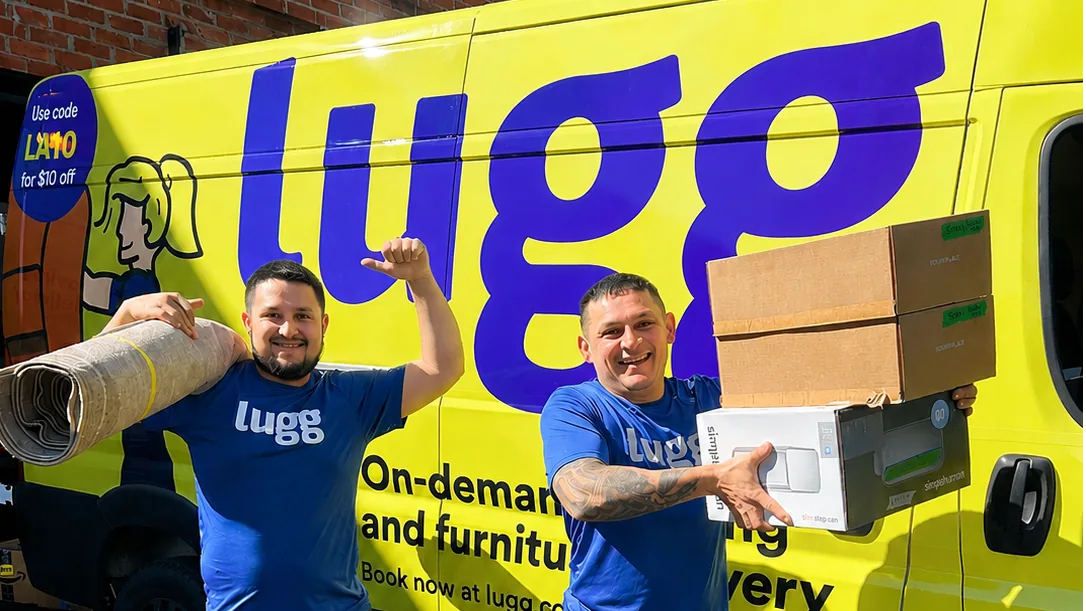 Two Luggers carrying a rug and boxes in front of a yellow Lugg van
