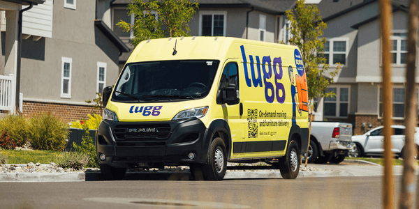 Bright yellow Lugg moving van with logo and tagline “On-demand moving and furniture delivery,” parked in a neighborhood to highlight fast, local moves.