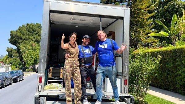 Lugg movers and happy customer standing next to a loaded moving truck