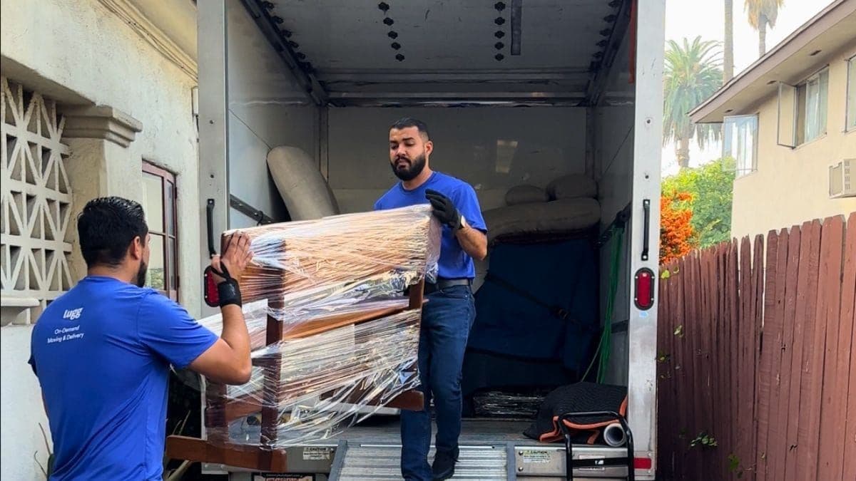 Lugg movers loading wrapped furniture into a box truck, a full-service alternative to renting a U-Haul.