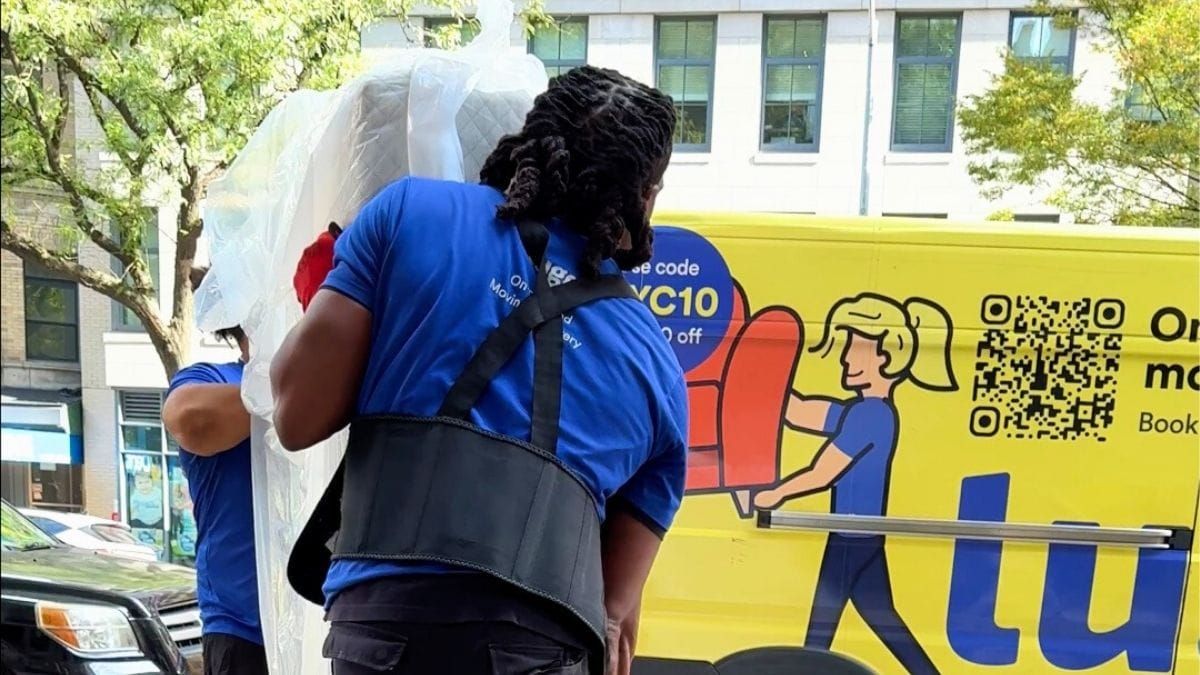 Lugg movers in blue shirts loading a wrapped mattress into a branded Lugg truck for a return