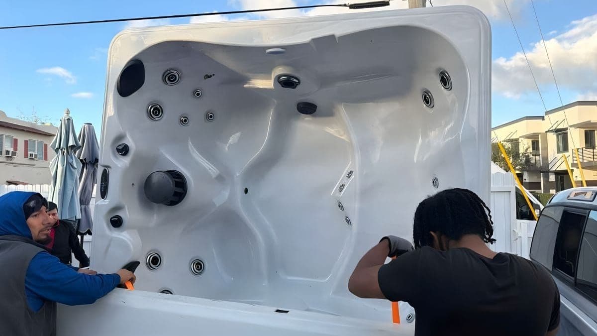 Three Lugg movers securing a hot tub in the bed of a pickup truck during an on-demand residential move