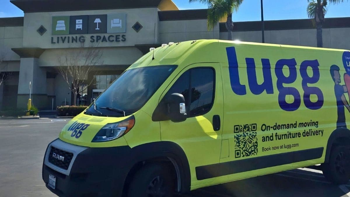 A Lugg cargo van parked outside a Living Spaces furniture storefront, ready for last mile delivery to a customer's home.