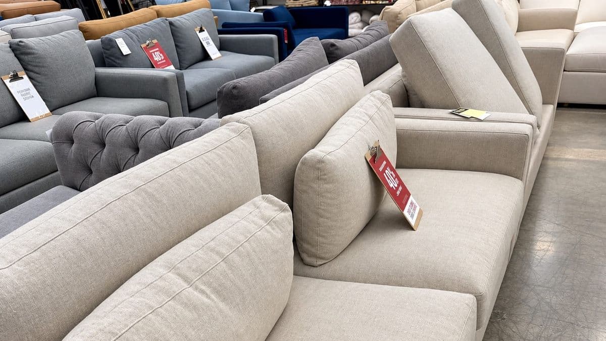 Sofas and armchairs in a furniture store with 40% off sale tags.
