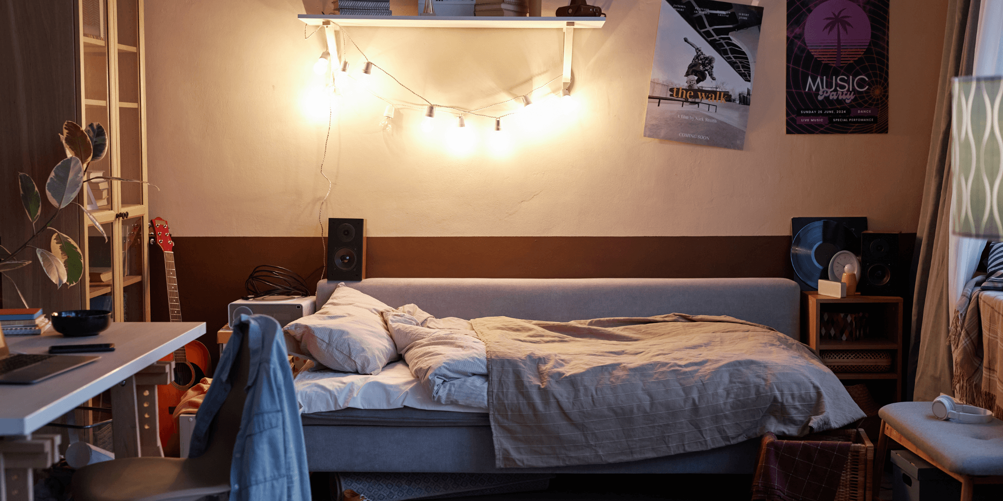 A decorated college dorm room with string lights above the bed, posters, and personal touches.