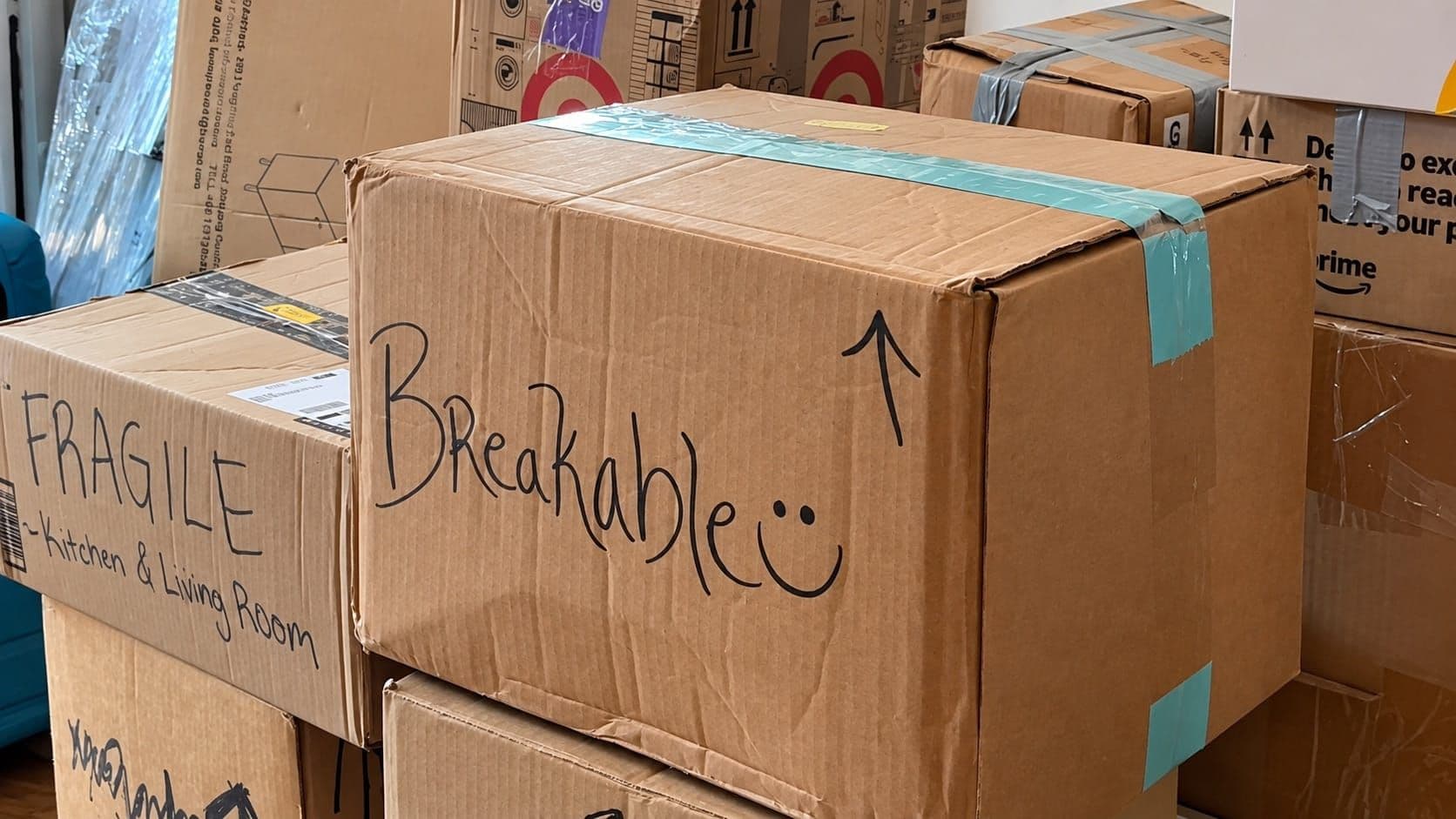 Reused moving boxes labeled for fragile household items and different rooms.