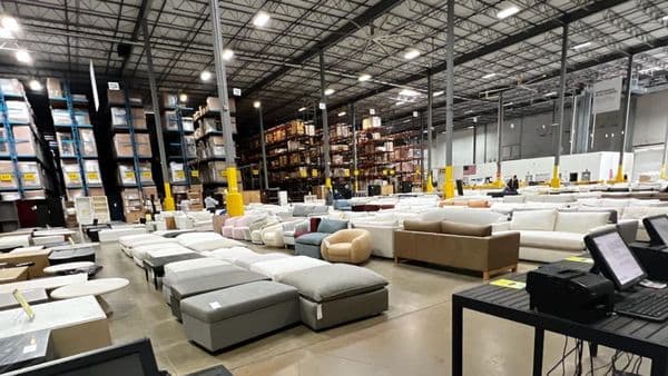 Warehouse-style discount furniture outlet filled with sofas, sectionals, and ottomans at clearance prices