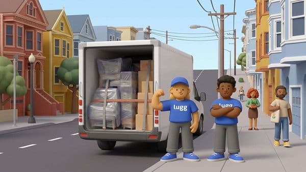 Two Lugg movers in blue shirts and caps stand beside an open moving truck loaded with shrink-wrapped furniture and boxes on a San Francisco street.